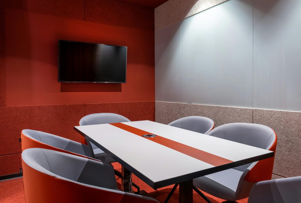 Contemporary office meeting room featuring bright orange accents and a sleek, modern design.
